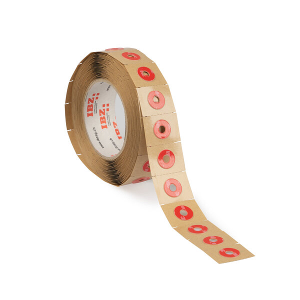 Die Abbildung zeigt selbstklebende Formstanzteile aus Acrylatklebeband mit Perforation, das in kleine rote Kreise mit Innenloch gestanzt wurde. Der Liner ist braun, der Hintergrund ist weiss