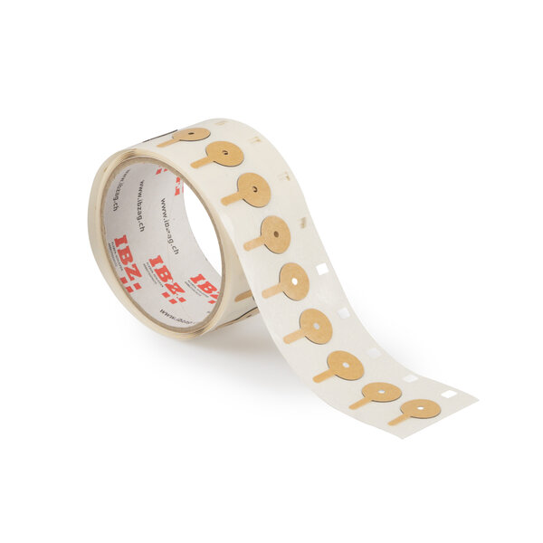 Die Abbildung zeigt selbstklebende Formstanzteile in Kreisform mit Anfasslasche. Der Liner und Hintergrund sind weiss.